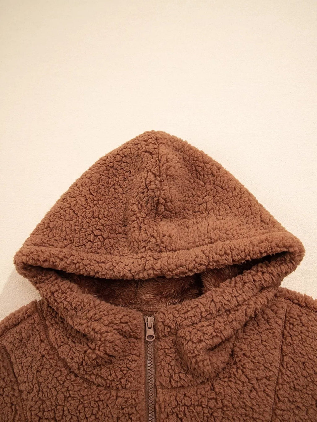 Front close-up of attached hood on women's brown teddy jacket