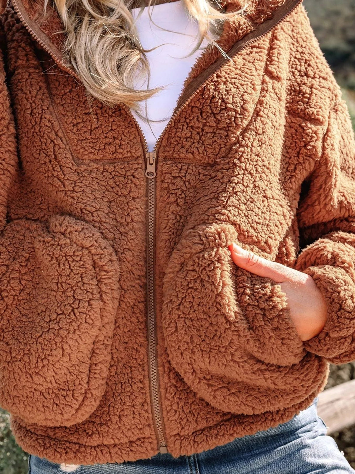 Close-up of women's brown teddy jacket front pocket and zipper