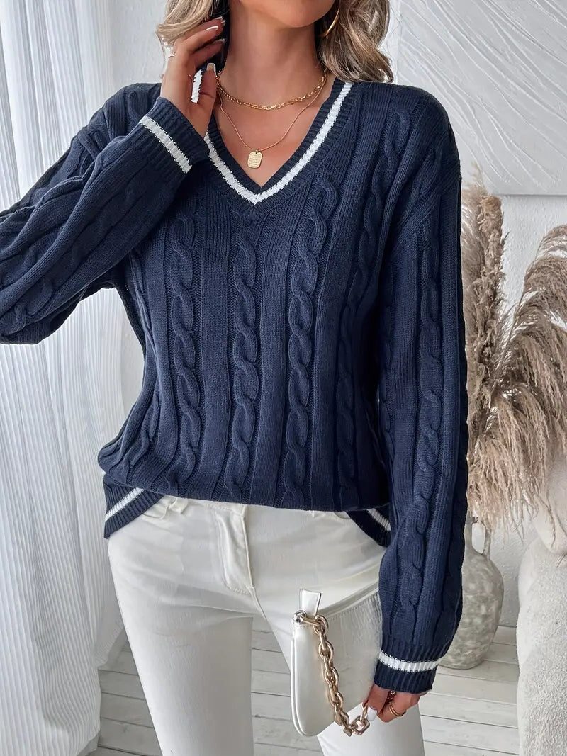 Women's navy cable knit sweater styled with white pants